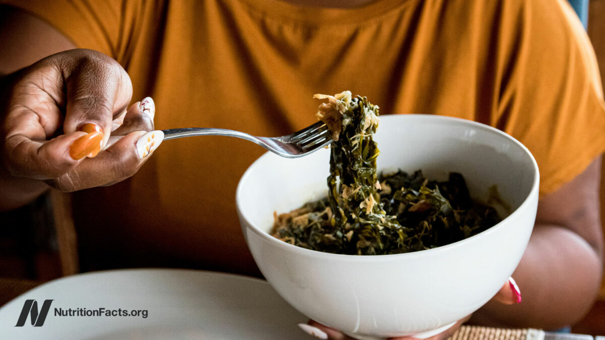 Person eating greens from a white bowl