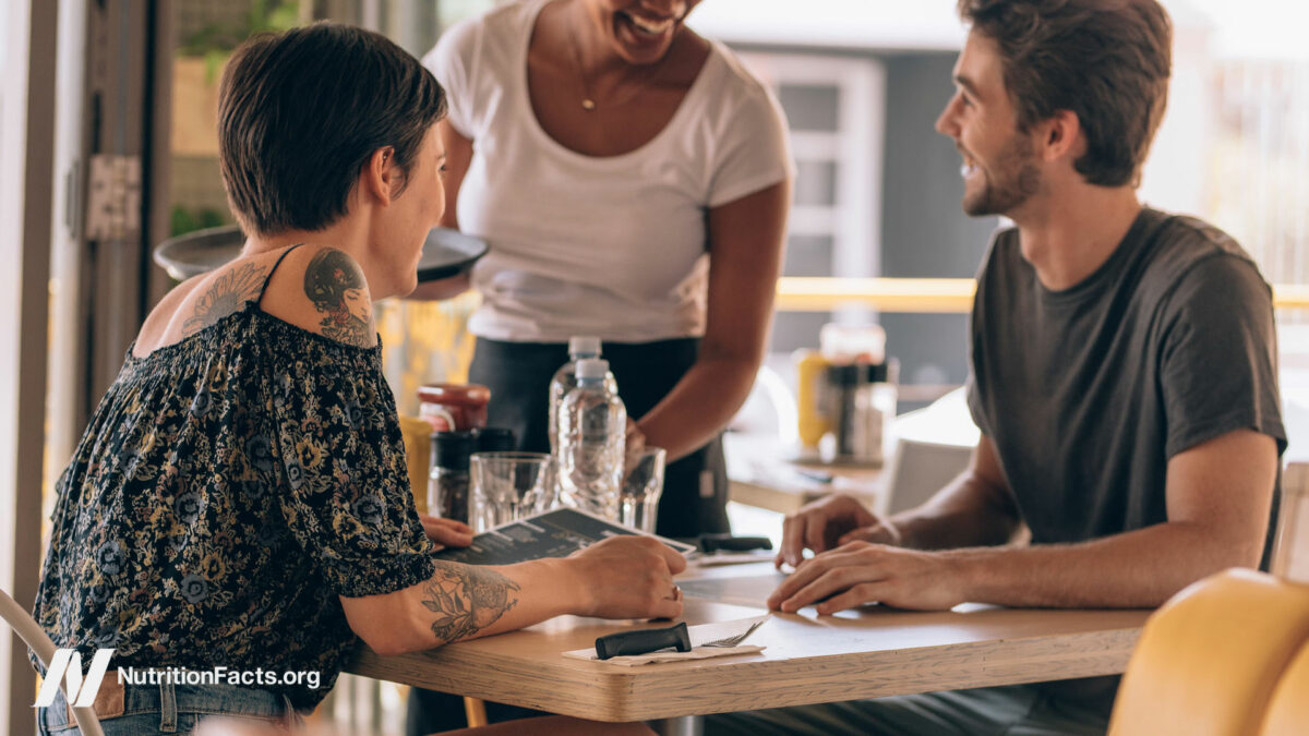 Two people out to eat with a server at the table