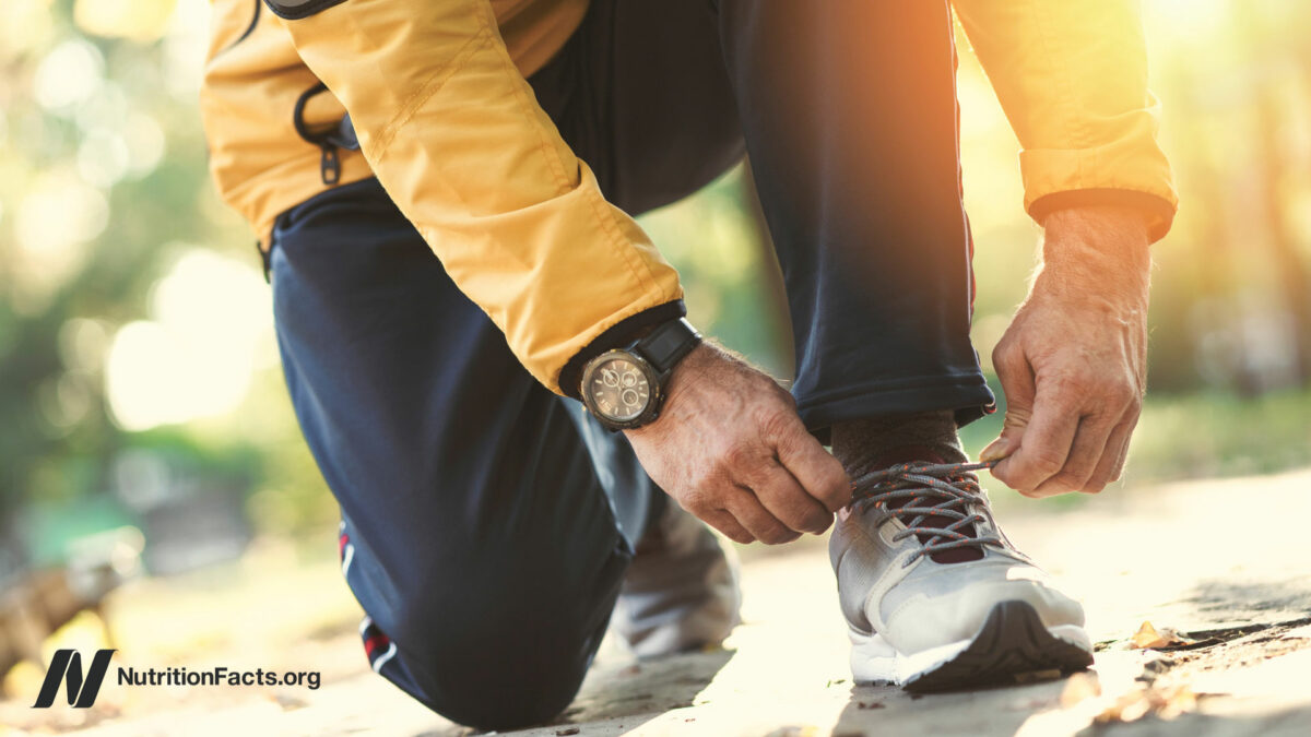 Older male kneeling down to tie sneakers