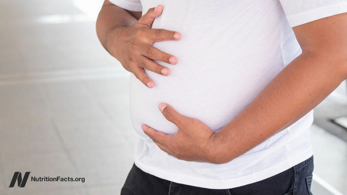 Person in a white shirt holding their stomach