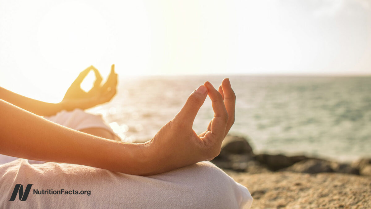 Close up of hands in a meditative pose on a beach