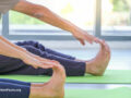 Close up of two people in forward fold