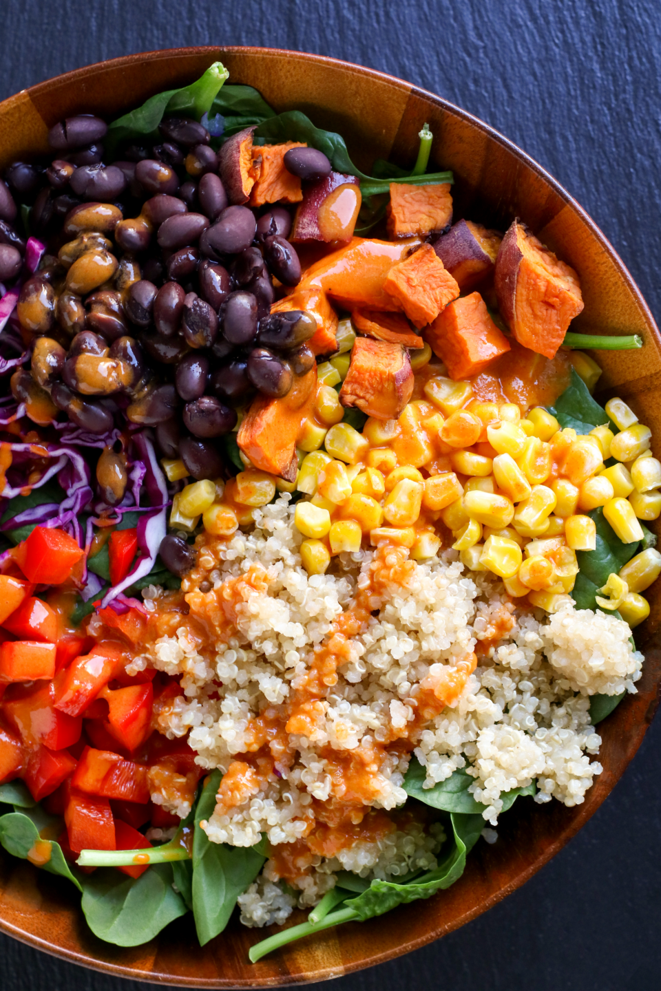large bowl of grains, beans, and vegetables, topped with sweet and smokey sauce