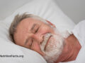 Older man sleeping soundly on white pillow