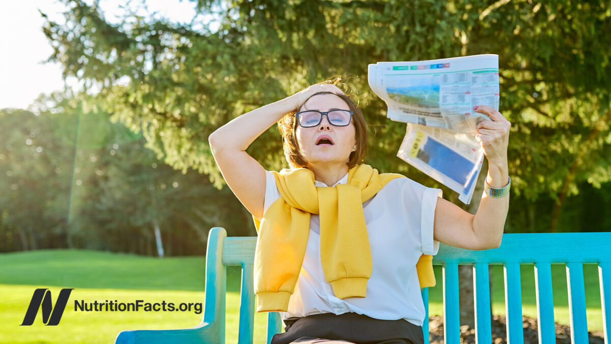 Woman experiencing hot flash on a bench outside