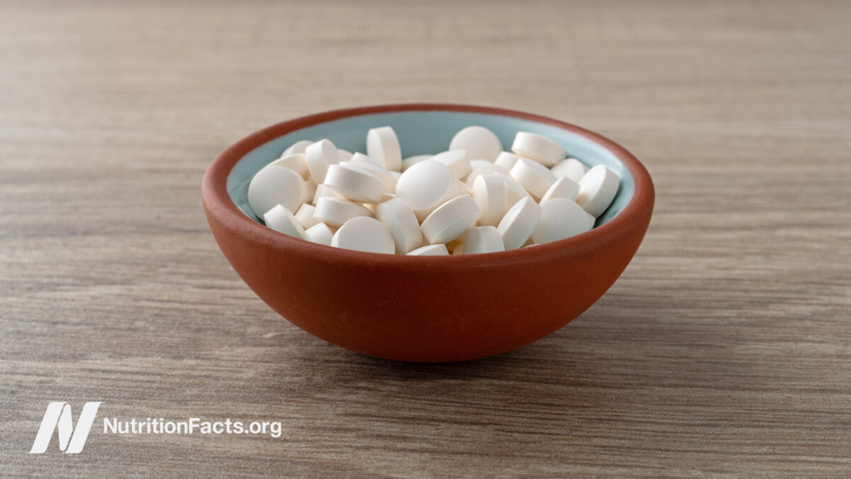 DHEA supplements in a bowl on brown surface