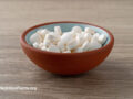 DHEA supplements in a bowl on brown surface