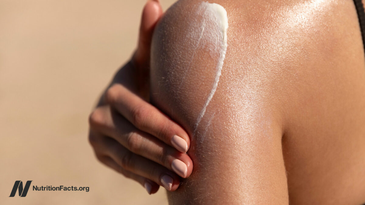 Person putting sunscreen on shoulder