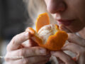 Woman sniffing an orange