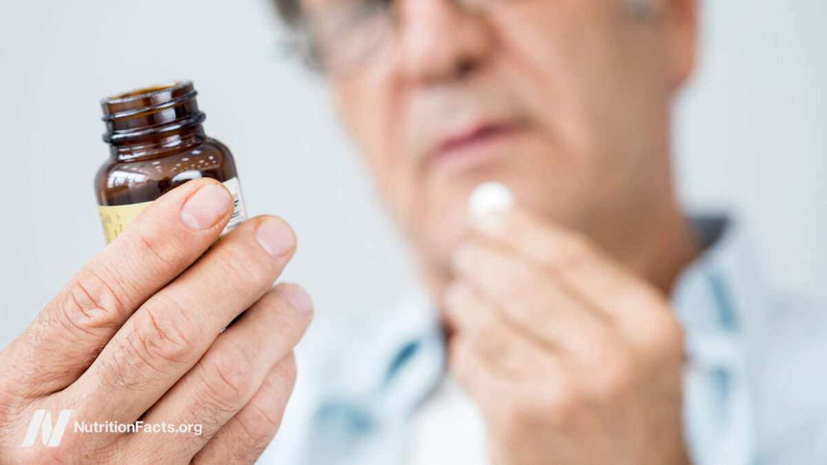 Old man taking a pill