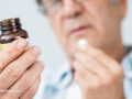 Old man taking a pill