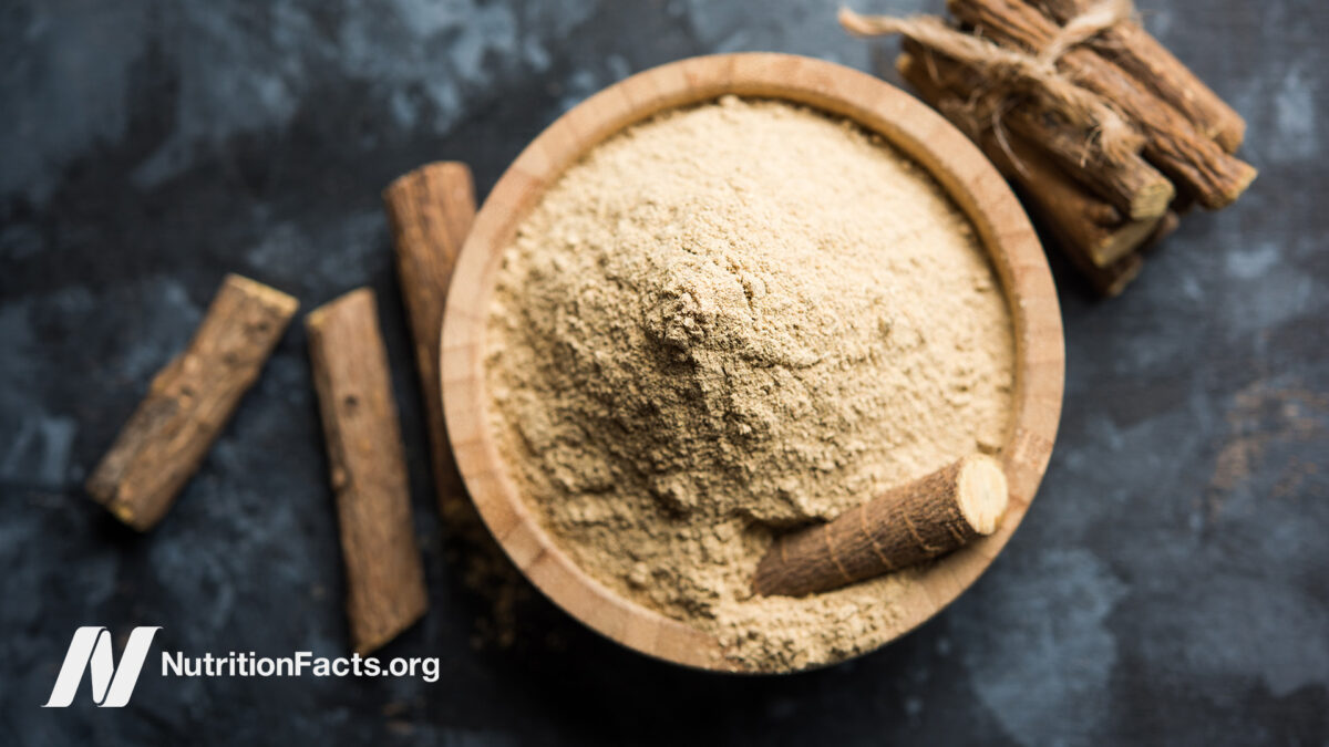 Licorice root ground up in a bowl on a dark surface