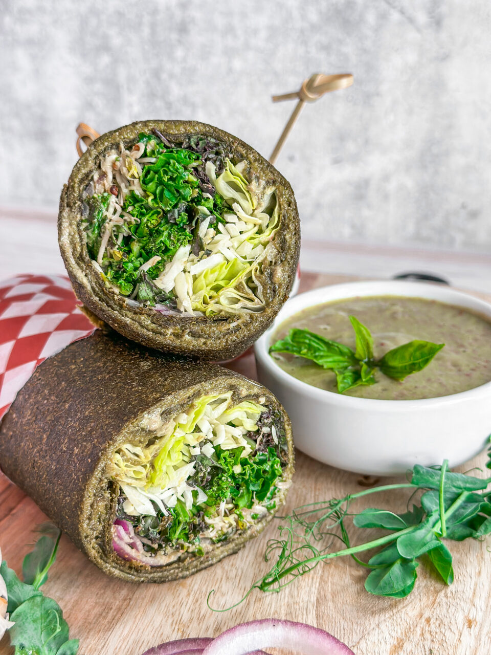 halved kale pesto wrap with a side dish of pesto