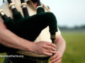 Close up view of someone playing bagpipes in a calm outdoor environment