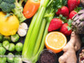An assortment of colorful fruits, vegetables, and legumes on a flat surface