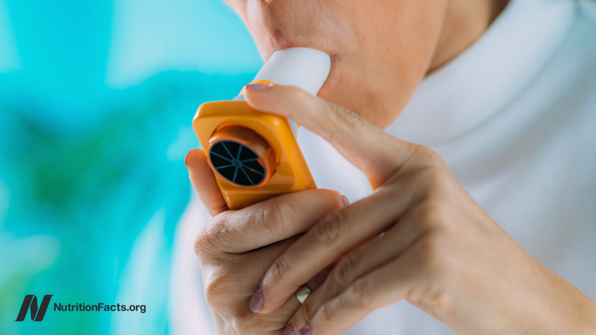 person blowing into spirometer