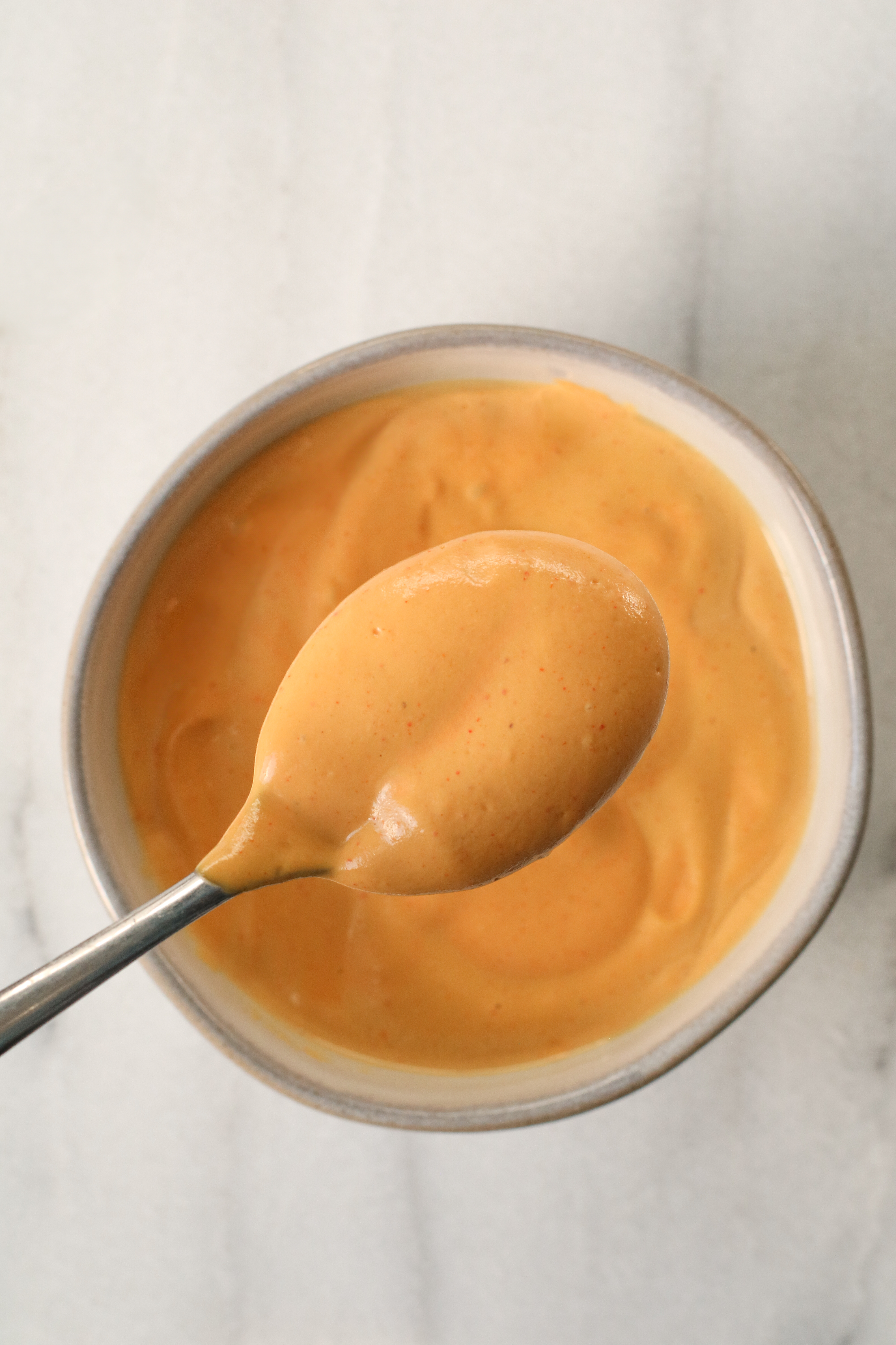 small ceramic bowl of cheesy sauce