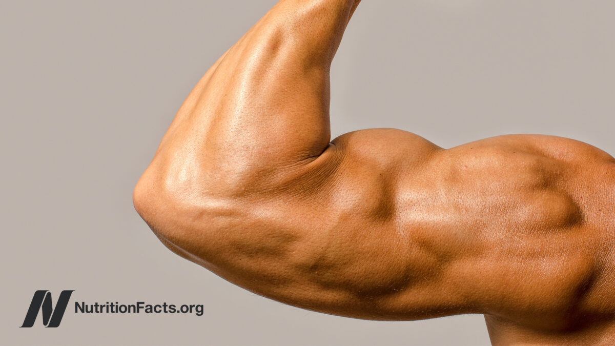 Closeup view of a large arms with muscles in front of a beige background
