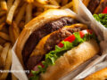 Closeup view of a double cheeseburger and a pile of french fries