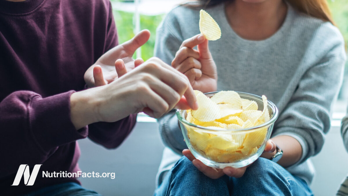 A couple sharing potato chips in a bowl