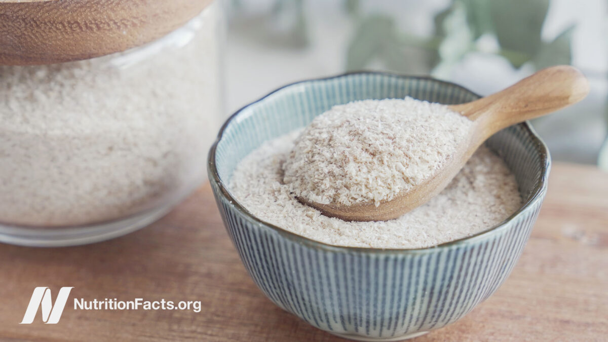 A glass jar of powdered psyllium husk next to a bowl of psyllium husk powder with a spoon inside