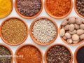 An overhead view of a variety of spices and herbs in bowls