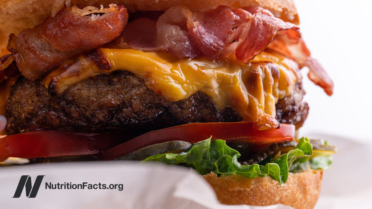 Closeup side view of a cheese burger with bacon