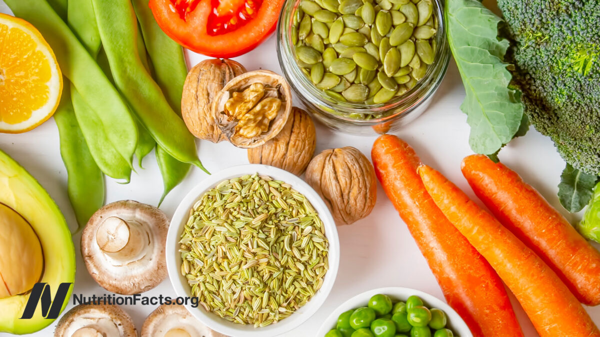 An array of whole plant foods, including green beans, avocado, cilantro, tomato, pepper