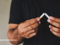 Person breaking a cigarette in half