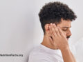 Side view of a person holding their ear