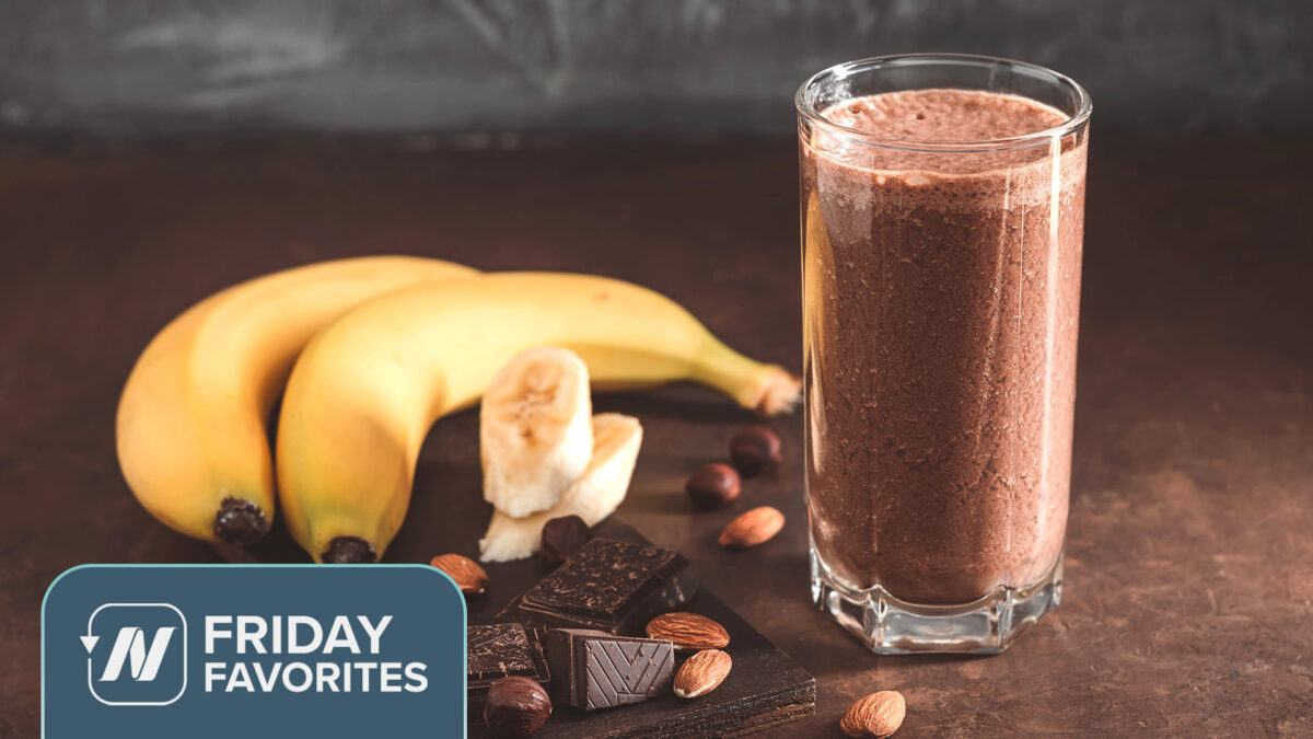 2 bananas, squares or dark chocolate and some almonds and hazelnuts beside a smoothie
