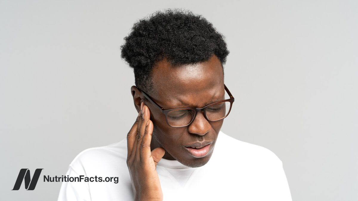 Person pressing their hand to the side of their face in pain