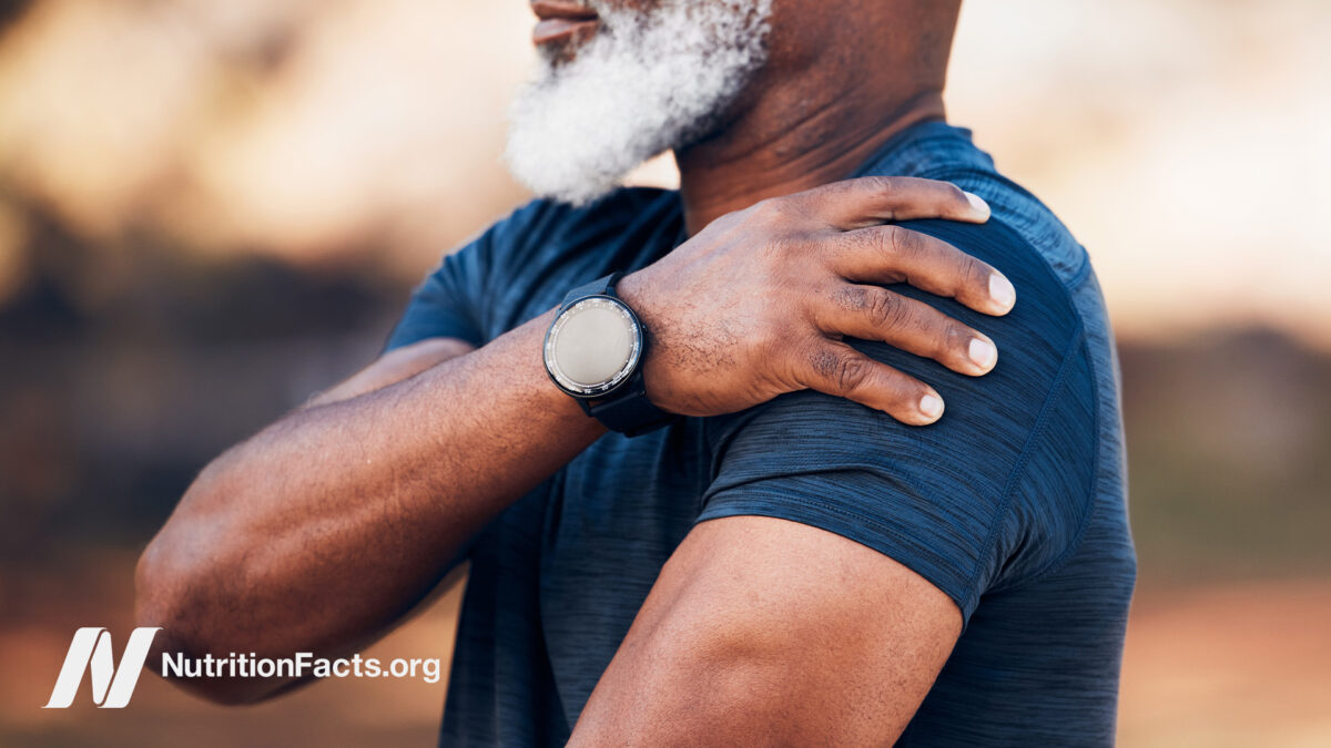 Older person of color holding their shoulder in discomfort